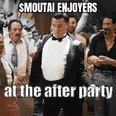 a man in a tuxedo and bow tie is standing in a crowd of people at a party .