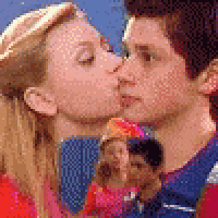 a man and a woman are kissing in front of a group of children .