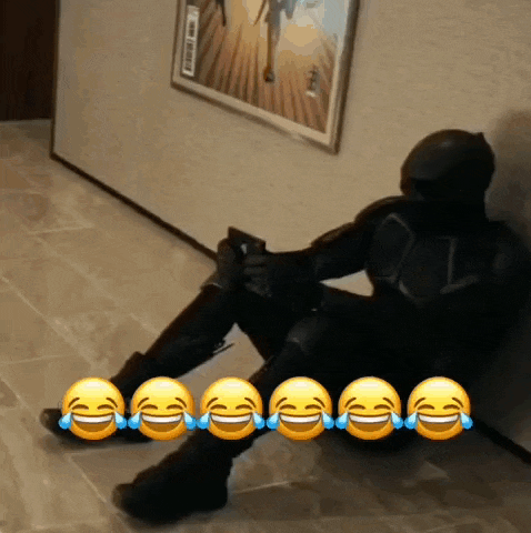 a man in a superhero costume is sitting on the floor laughing with tears running down his face