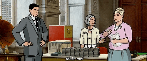 a man in a suit and tie stands next to two women and says " make me "