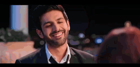 a man in a suit and tie is smiling and looking at another man .