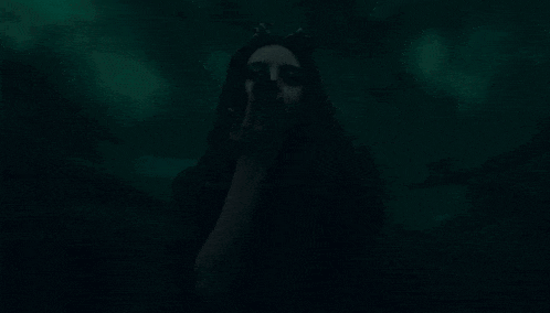 a woman in a cat costume is standing in the dark .