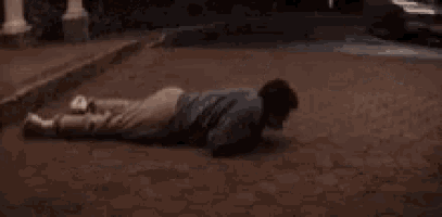 a person is laying on the ground next to a white sports car .