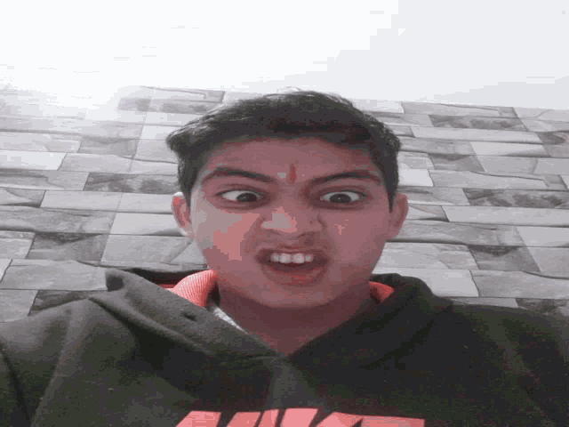 a young man wearing a nike sweatshirt makes a face