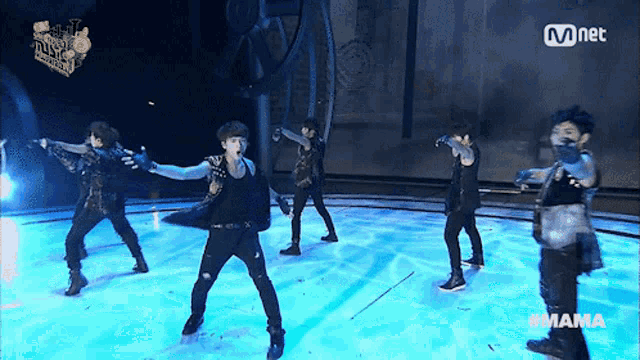 a group of young men are performing on a stage with mnet written on the bottom