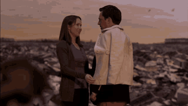 a man and a woman are holding hands in a field