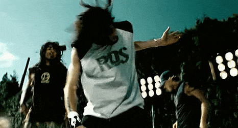 a man wearing a shirt that says pos is dancing