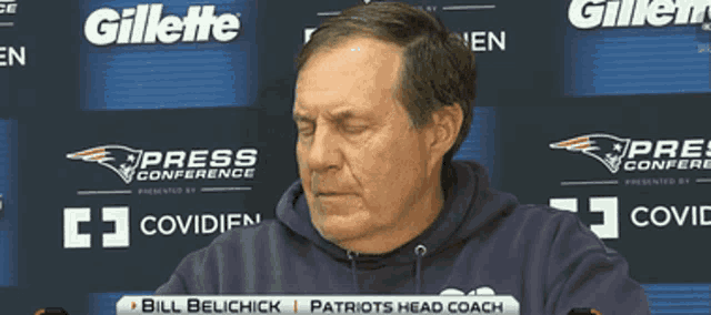 a man sitting in front of a sign that says gillette