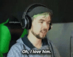 a man with green hair and headphones is sitting in a chair and saying `` oh , i love him . ''