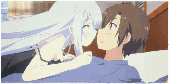 a man and a woman are laying on a bed and the woman is kissing the man on the cheek