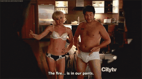 a man and a woman are standing next to each other and the woman says " the fire is in our pants "