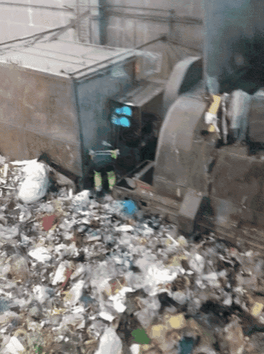 a pile of garbage is being loaded into a truck