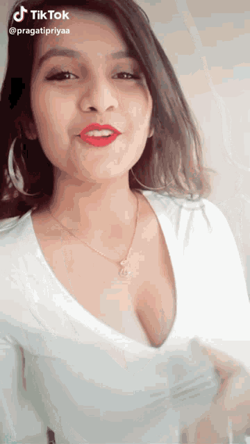 a tiktok video of a woman with a necklace and red lips