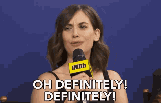 a woman is talking into an imdb microphone and saying oh definitely definitely !