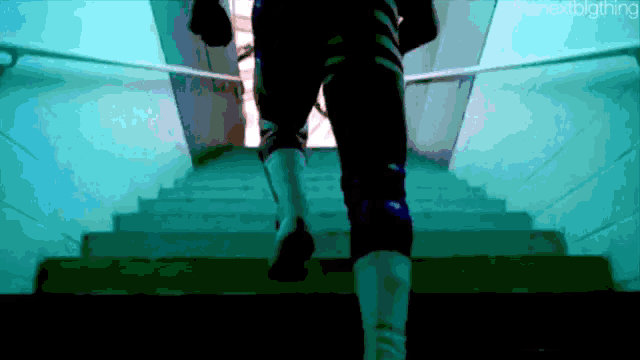 a person is walking up a set of stairs with the word " planetclothing " on the bottom left