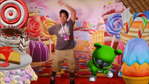 a man is dancing in front of a wall with candy in the background