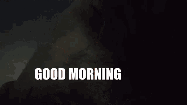 a man with a beard is saying good morning with his hand on his face