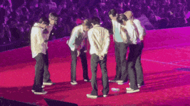 a group of people are dancing on a stage with a crowd watching .