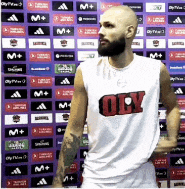 a bald man with a beard wearing a white tank top with the word oily on it