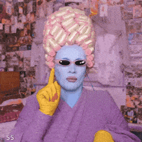a woman with curlers in her hair is wearing a purple robe