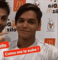 a man in a white shirt has a red sticker on his shirt that says como me la sube