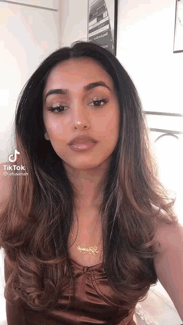 a woman with long hair is wearing a necklace that says veronica
