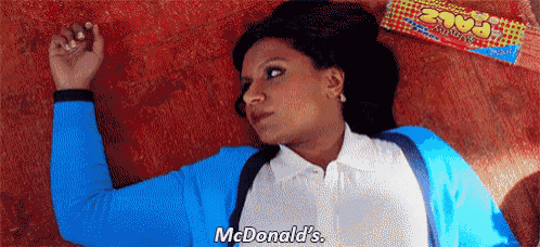 a woman is laying on the floor next to a mcdonald 's bag