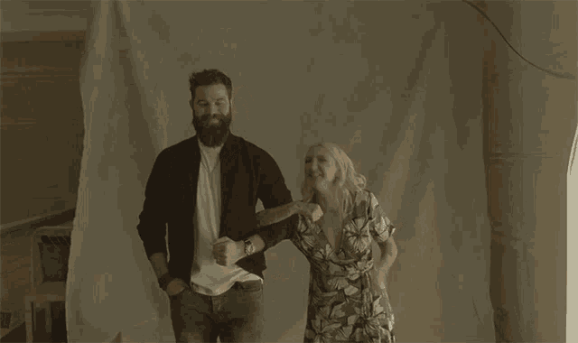 a man with a beard and a woman with blonde hair are dancing