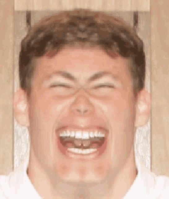 a man is making a funny face with his eyes closed and his mouth open .