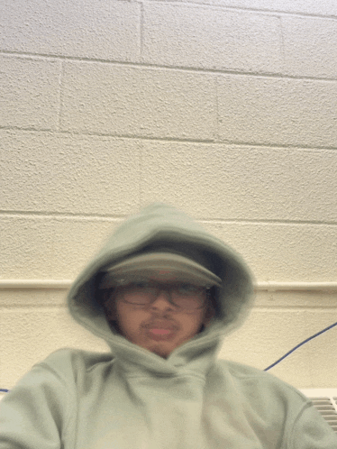 a blurry picture of a man wearing a hoodie and glasses