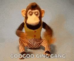 a stuffed monkey in striped pants is sitting on the floor .