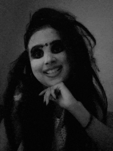 a woman with a bindi on her forehead is smiling