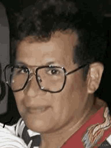 a close up of a person wearing glasses and a red shirt