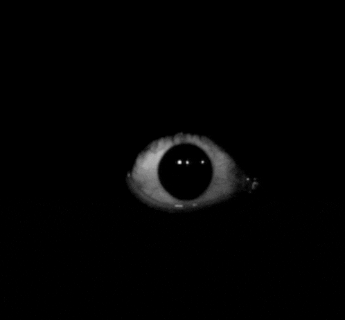 a close up of a person 's eye in the dark