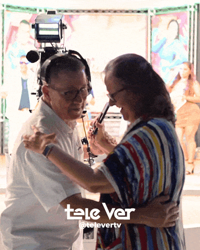 a man and a woman are dancing in front of a tele ver logo