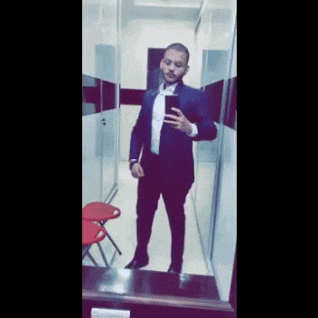 a man in a suit taking a selfie in front of a mirror .