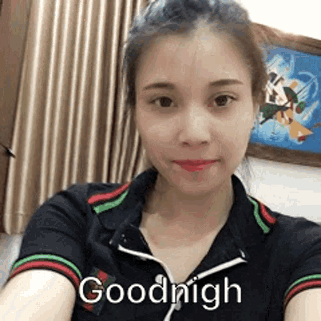 a woman in a black shirt is taking a selfie and says goodnight .