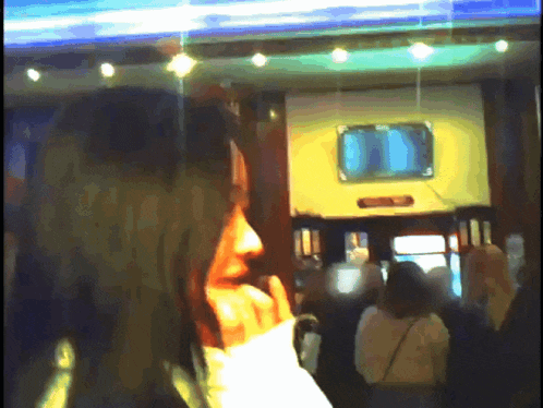 a blurry picture of a woman talking on a phone in a room