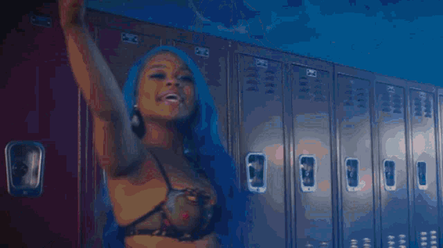 a woman with blue hair is standing in a crowd of people