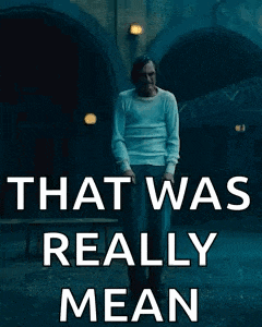 a man in a white shirt is standing in front of a sign that says that was really mean .
