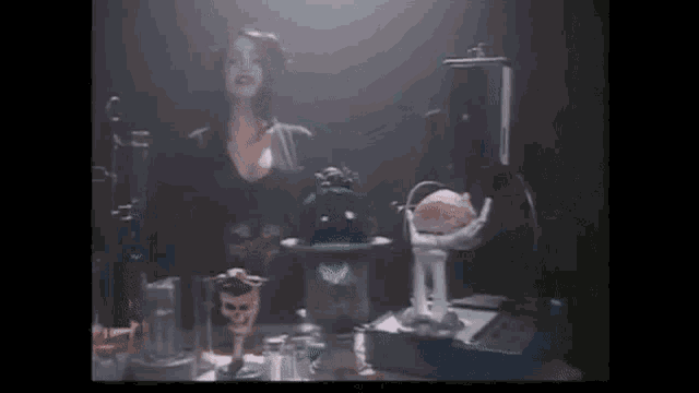 a woman is standing in front of a table with a bunch of skulls and a brain on it .