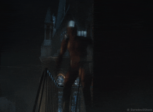 a man in a daredevil costume stands on a set of stairs
