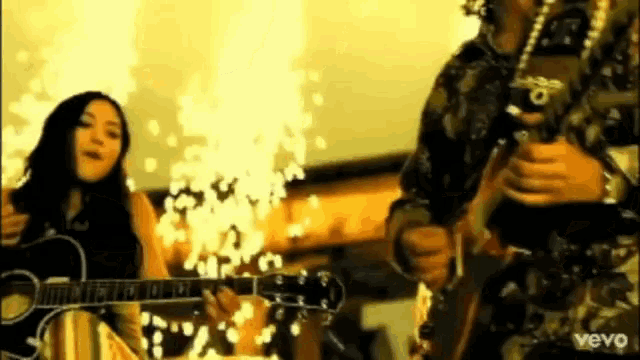 a woman playing a guitar next to a man playing a guitar in a video that says vevo