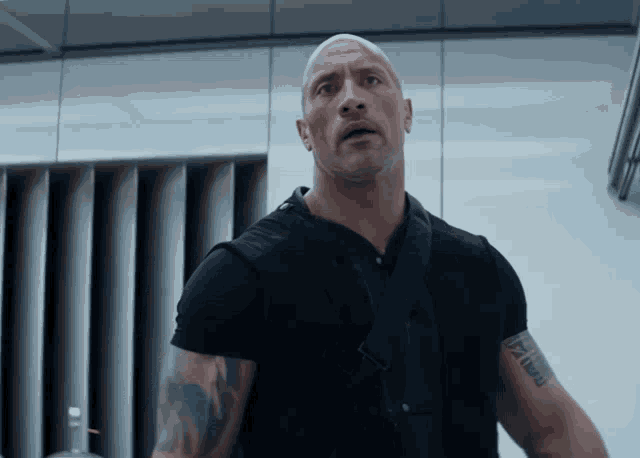 a bald man with a tattoo on his arm that says ' i am a man '