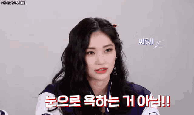 a woman with long black hair is wearing a purple and white jacket and talking in korean .
