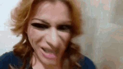 a woman with red hair is making a funny face with her mouth open .