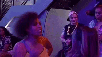 a group of people are dancing at a party in a dark room .
