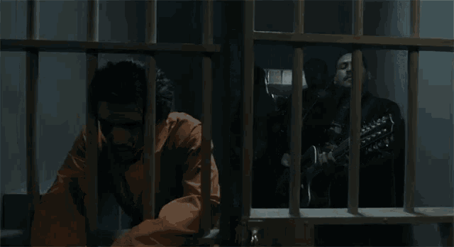 a man in a jail cell with a guitar behind bars