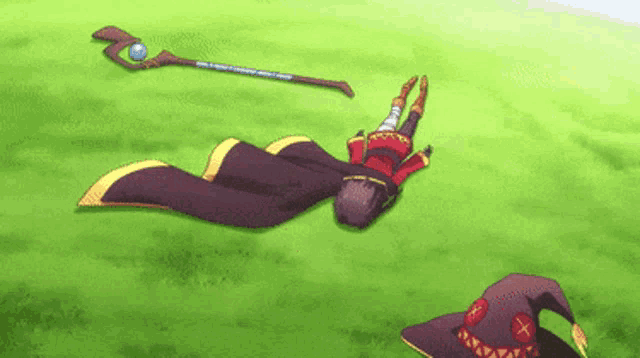 a cartoon character is laying on the grass with a staff and a witch hat .