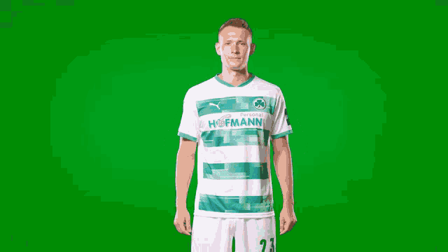 a man in a green and white hofmann shirt